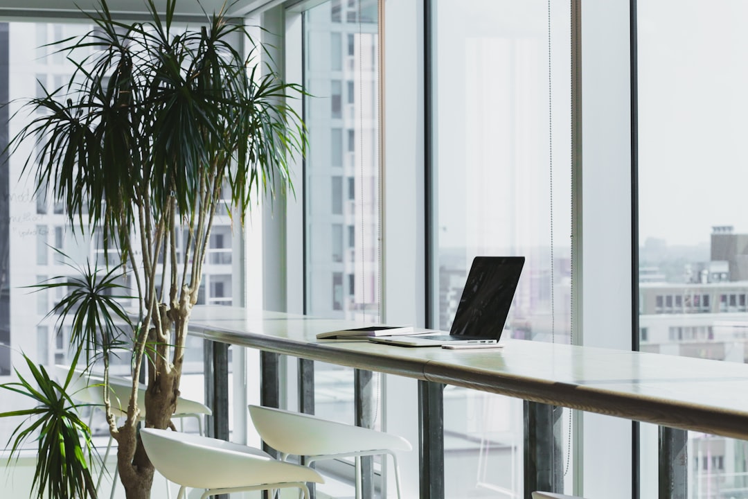 bright modern office with white desks and green plants
